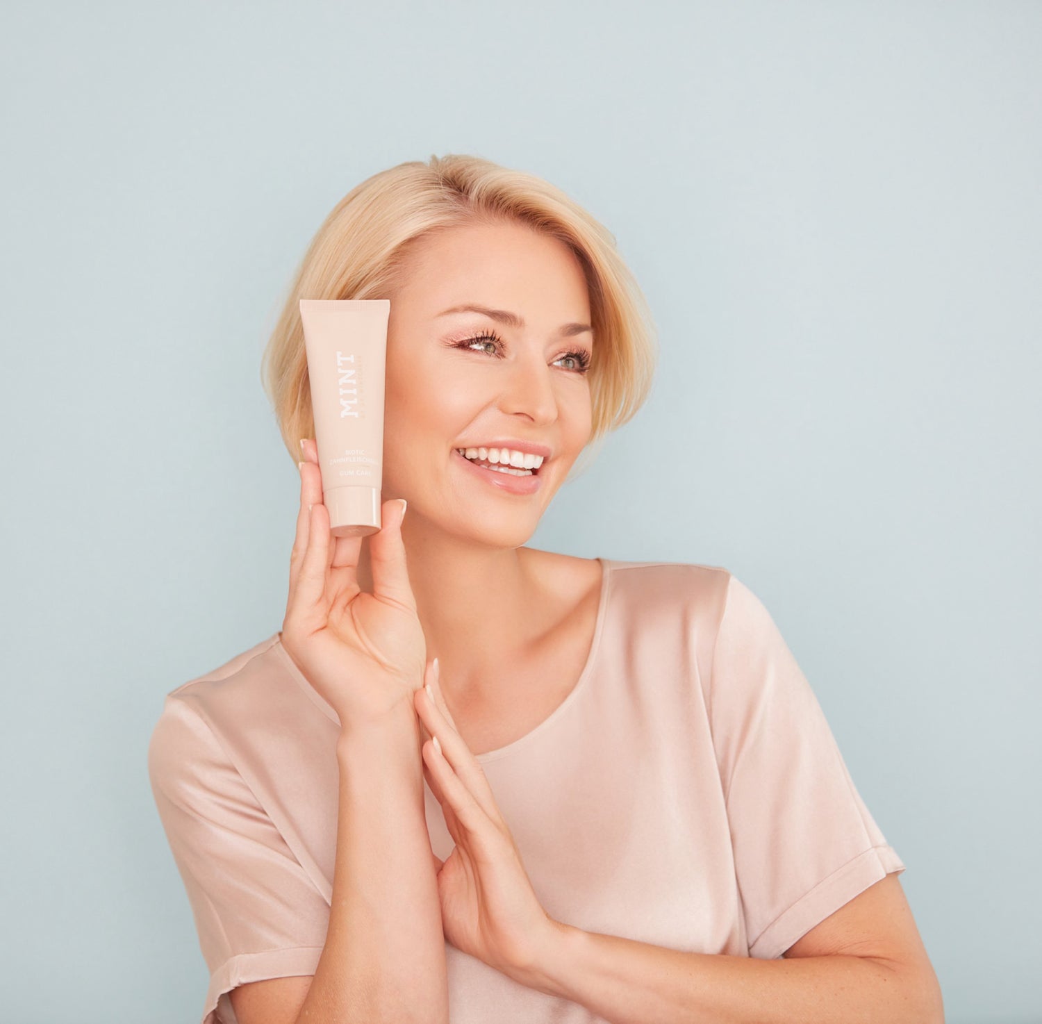 Model präsentiert MINT Biotic Zahnpastatube