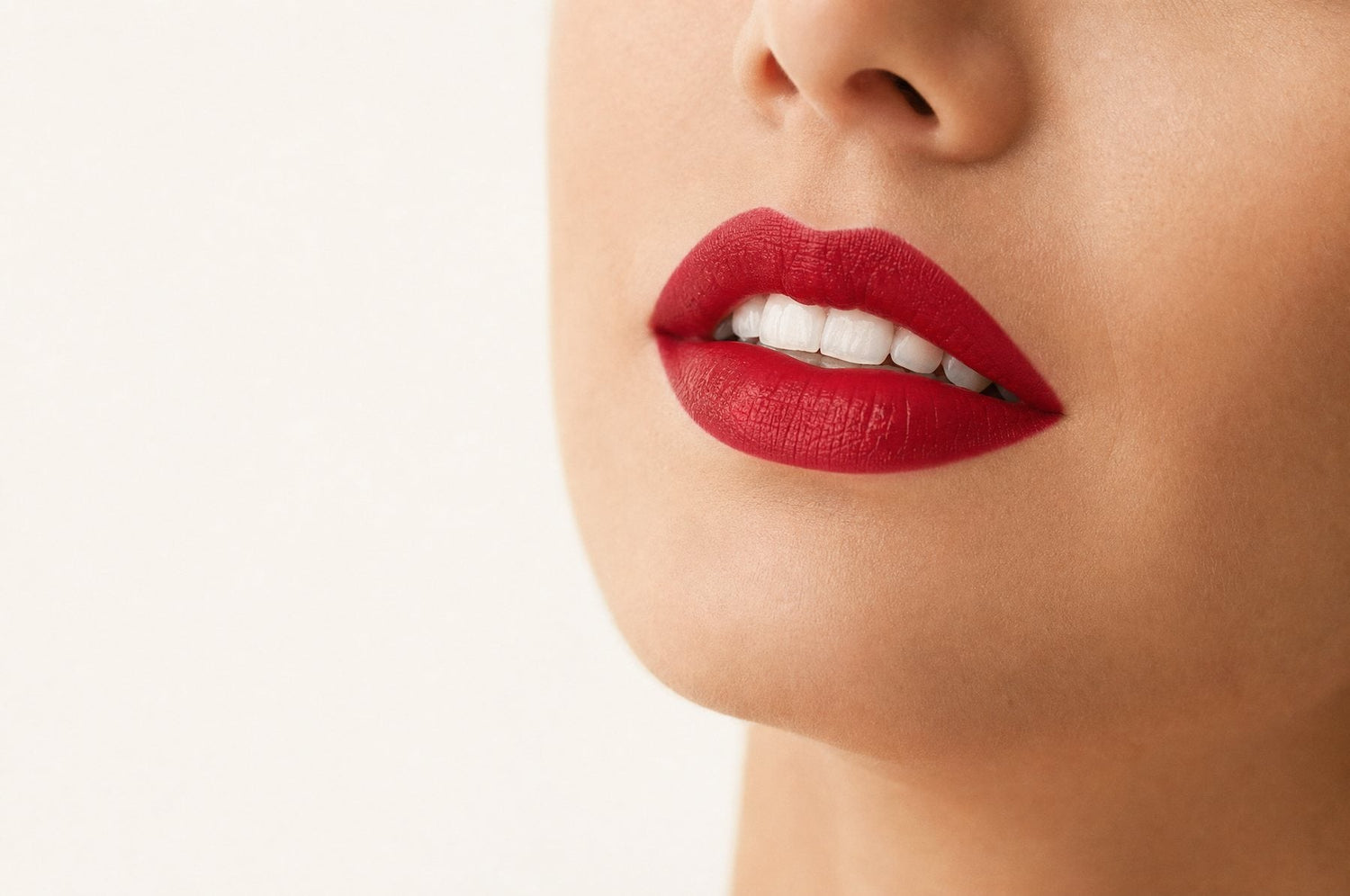 Lippen mit blaustichig rotem Lippenstift und hell wirkenden Zähnen