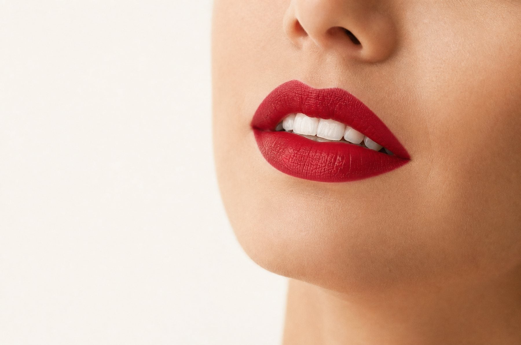 Lippen mit blaustichig rotem Lippenstift und hell wirkenden Zähnen