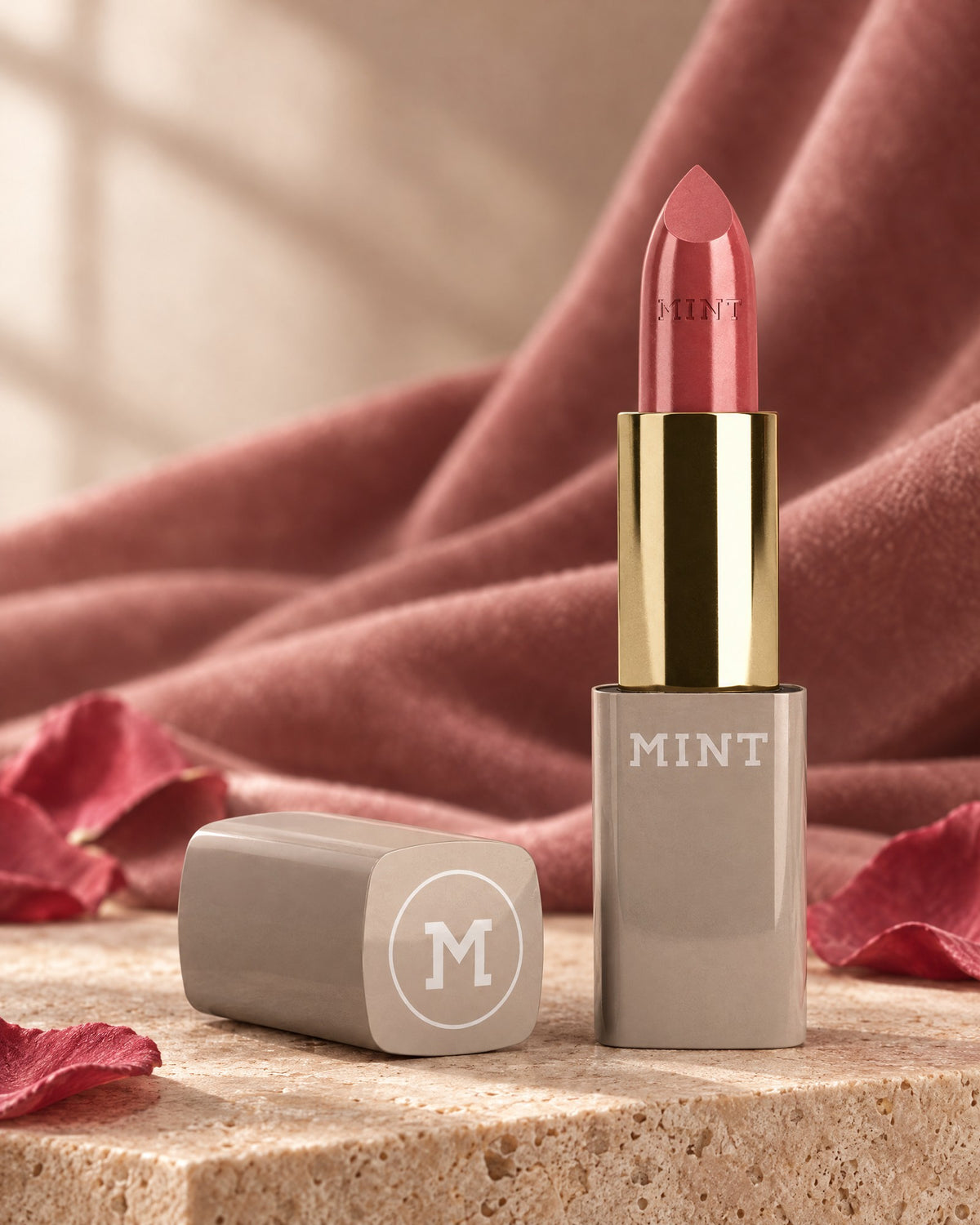 MINT Lippenstift Velvet Rosé auf Travertin mit Rosenblättern